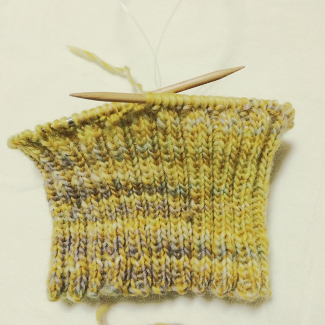 輪針で編み始めた手編みの毛糸の帽子　コードよりも小さい輪を編む